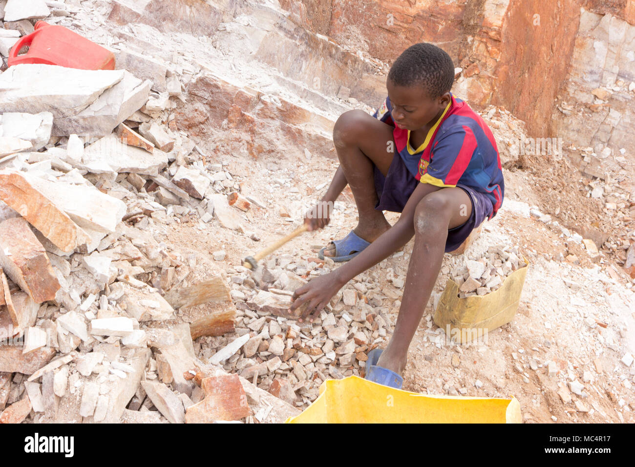 Lugazi, en Ouganda. 18 juin 2017. Un garçon ougandais casser des pierres dans les petites dalles à son contremaître. Fondamentalement, le travail des enfants. Banque D'Images