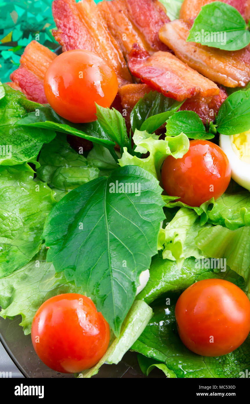 Détail d'une plaque avec les tomates cerises, les herbes, l'huile d'olive, des œufs et du bacon close up avec blur Banque D'Images