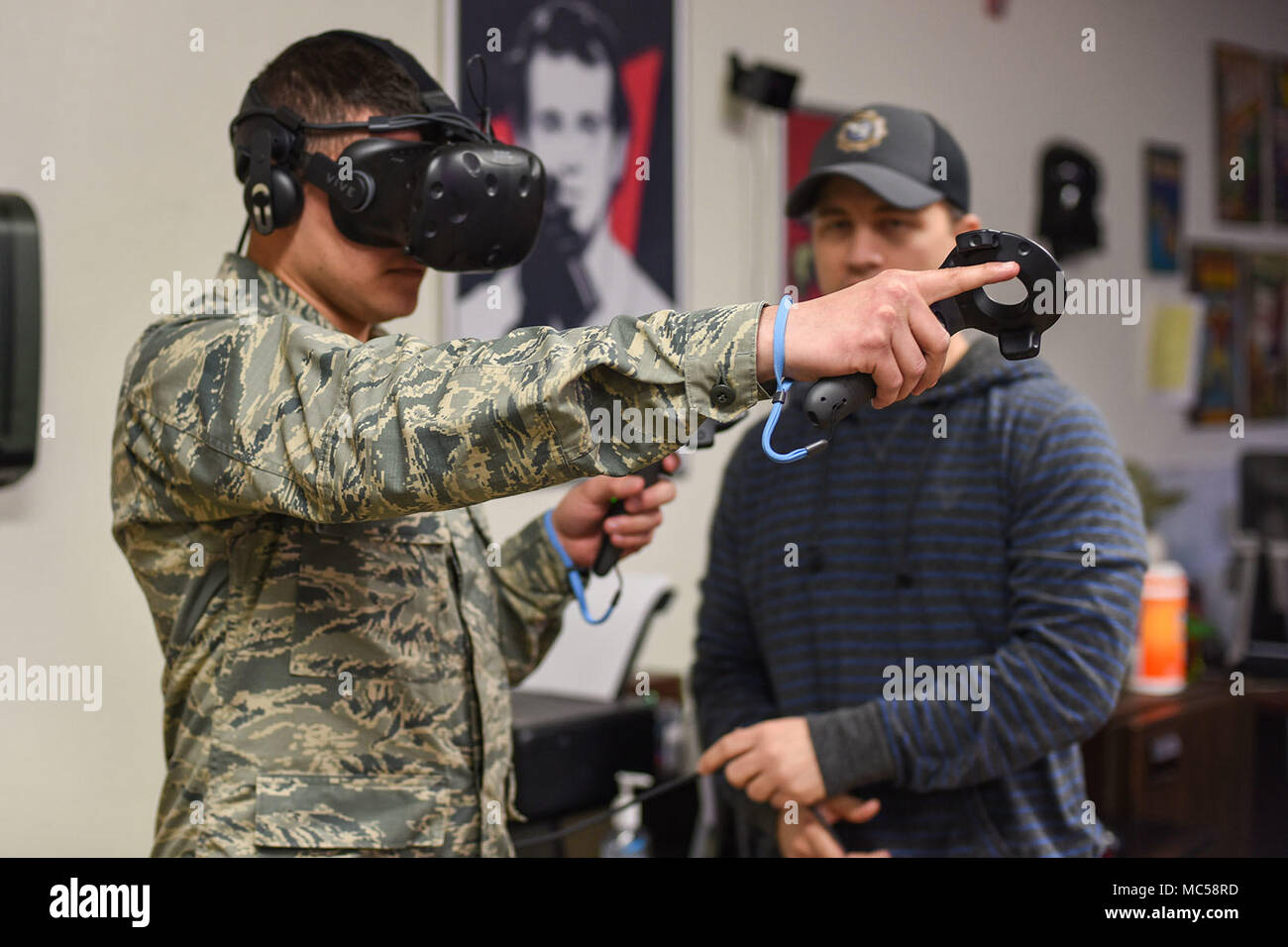 Un 366e Escadron de formation systèmes électriques cours apprenti étudiant à Sheppard Air Force Base, Texas, essaie d'appuyer sur un bouton virtuel à l'intérieur d'un ascenseur Le 26 janvier 2018, sous la supervision de James Rumfelt, membre de la 82e Escadre de formation numérique Affaires publiques Design Lab. Les contrôles du système de réalité virtuelle sont assez simples pour un tel complexe. Les contrôleurs inexploitables sont sans fil et disposent d'un bouton et d'un trigger sur eux pour saisir et pousser les éléments dans le monde virtuel. (U.S. Air Force photo par un membre de la 1re classe Pedro Tenorio) Banque D'Images