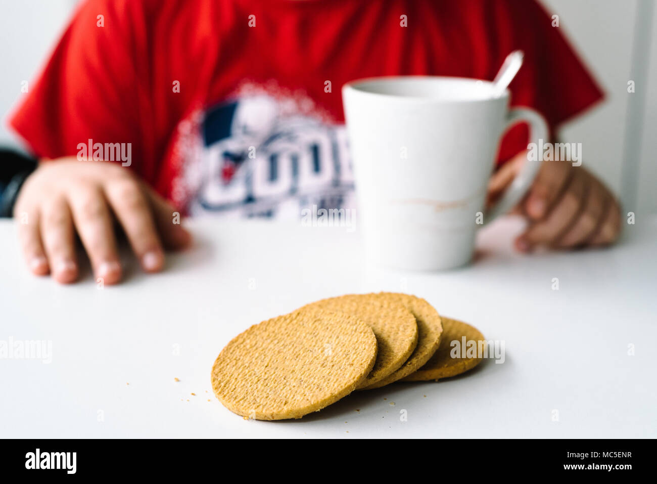 Close up of boy ayant un petit-déjeuner composé de biscuits, de se concentrer sur des biscuits. Santé Concept Banque D'Images