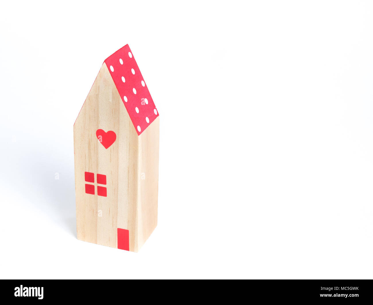 La miniature maison au toit rouge et cœur rouge sur fond blanc Banque D'Images