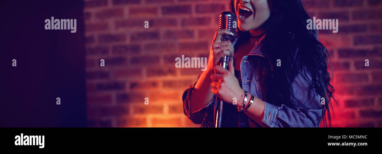Cheerful singer singing allumé en discothèque Banque D'Images Cheerful singer singing allumé en discothèque Banque D'Images