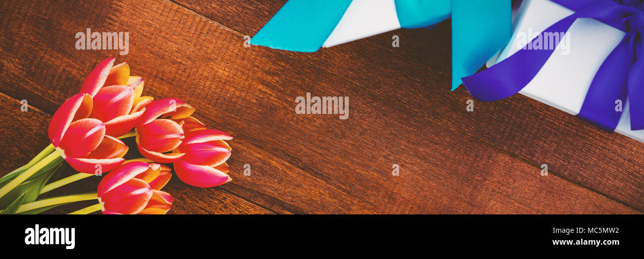 Des fleurs colorées et de cadeaux sur plancher en bois Banque D'Images Des fleurs colorées et de cadeaux sur plancher en bois Banque D'Images