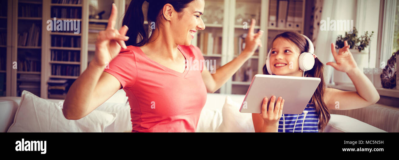 Happy mother and daughter using digital tablet et danse Banque D'Images Happy mother and daughter using digital tablet et danse Banque D'Images