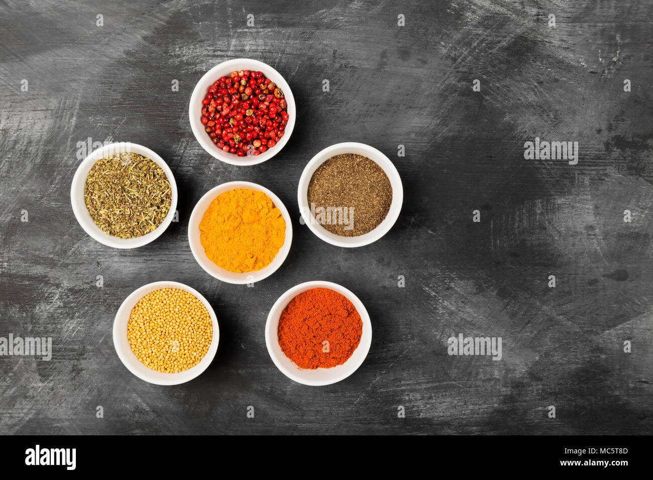 Épices diverses dans des bols sur fond noir. Vue de dessus, copiez l'espace. Arrière-plan de l'alimentation Banque D'Images