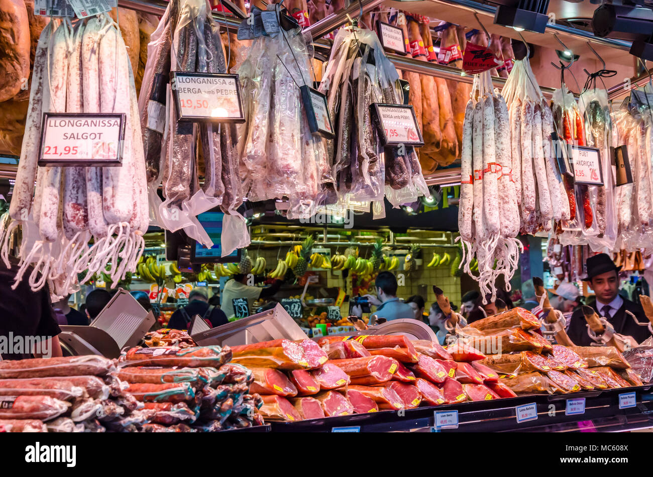 Une épicerie fine au marché public de La Boqueria à Barcelone la vente de saucisses et de jambons. Banque D'Images