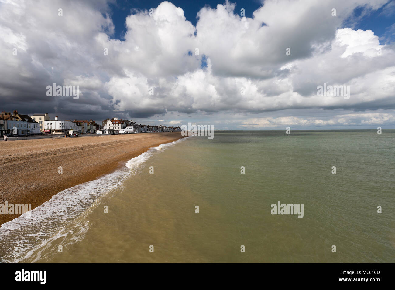 Voir à partir de la jetée de Deal à la recherche vers l'Ile avec de gros nuages et lumière douce tombant sur la plage de galets. Kent, UK. Banque D'Images