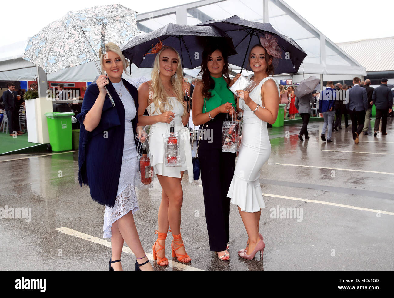 Femme racegoers à l'abri de la pluie au cours de la journée chers Randox 2018 Grand Festival National de Santé à Aintree Hippodrome, Liverpool. Banque D'Images