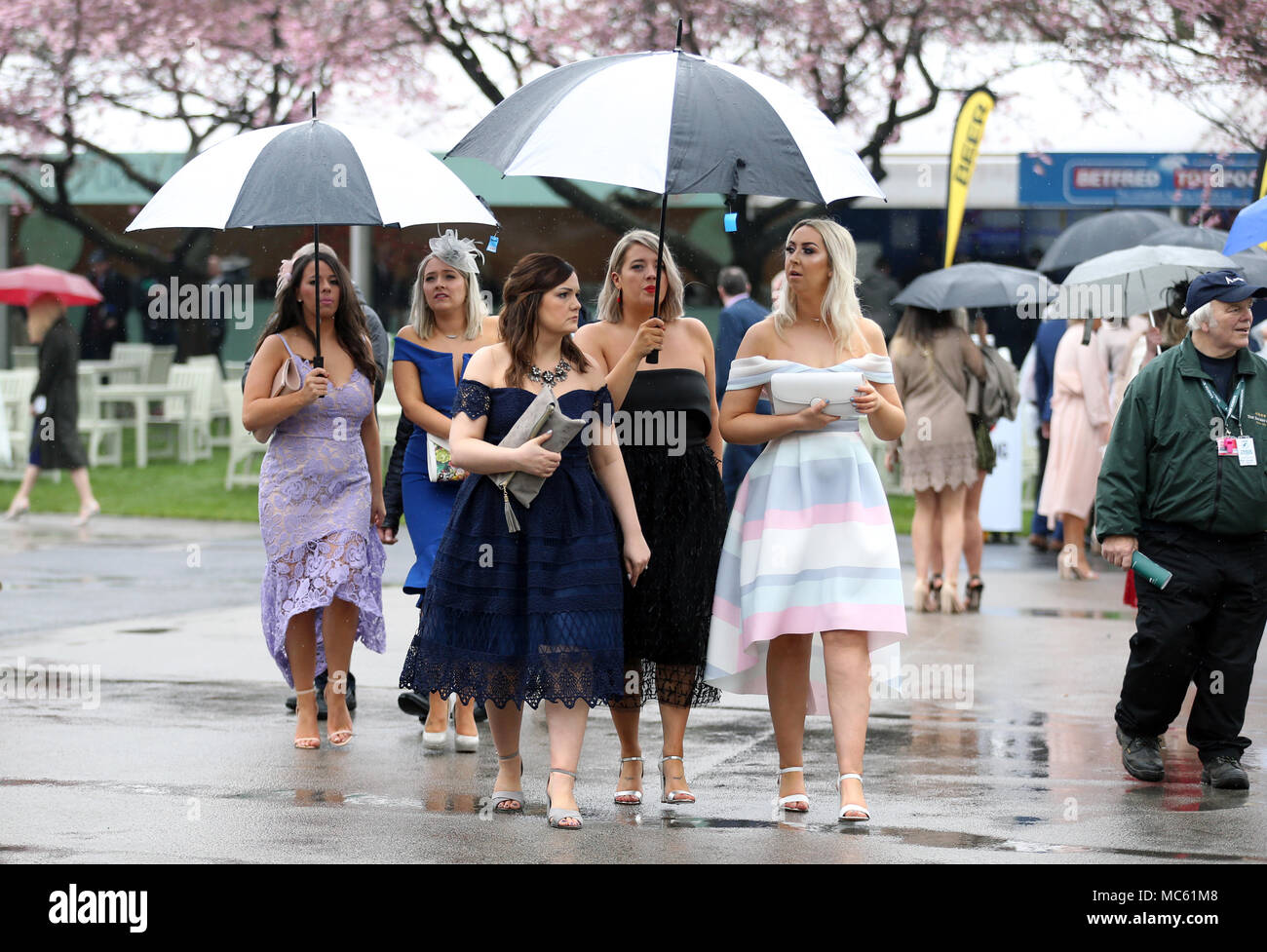 Racegoers à l'abri de la pluie sur Mesdames Jour de la Randox 2018 Grand Festival National de Santé à Aintree Hippodrome, Liverpool. Banque D'Images