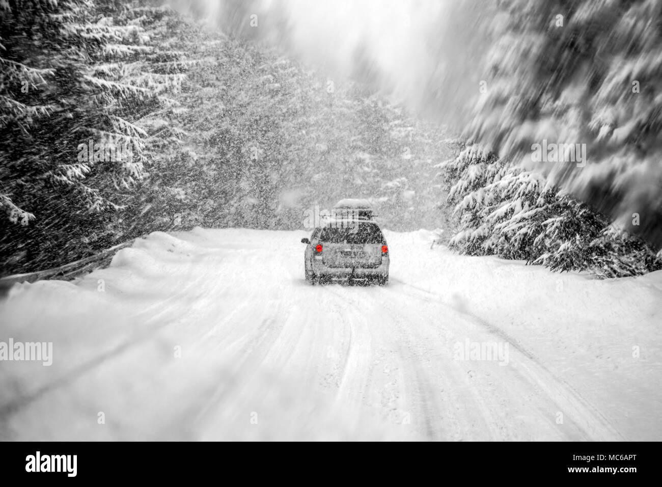 La conduite automobile en hiver neige prises à travers un pare-brise couvert de flocons blured. Banque D'Images