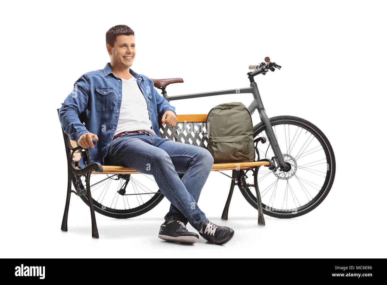 Jeune homme avec un vélo et un sac à dos, assis sur un banc isolé sur fond blanc Banque D'Images