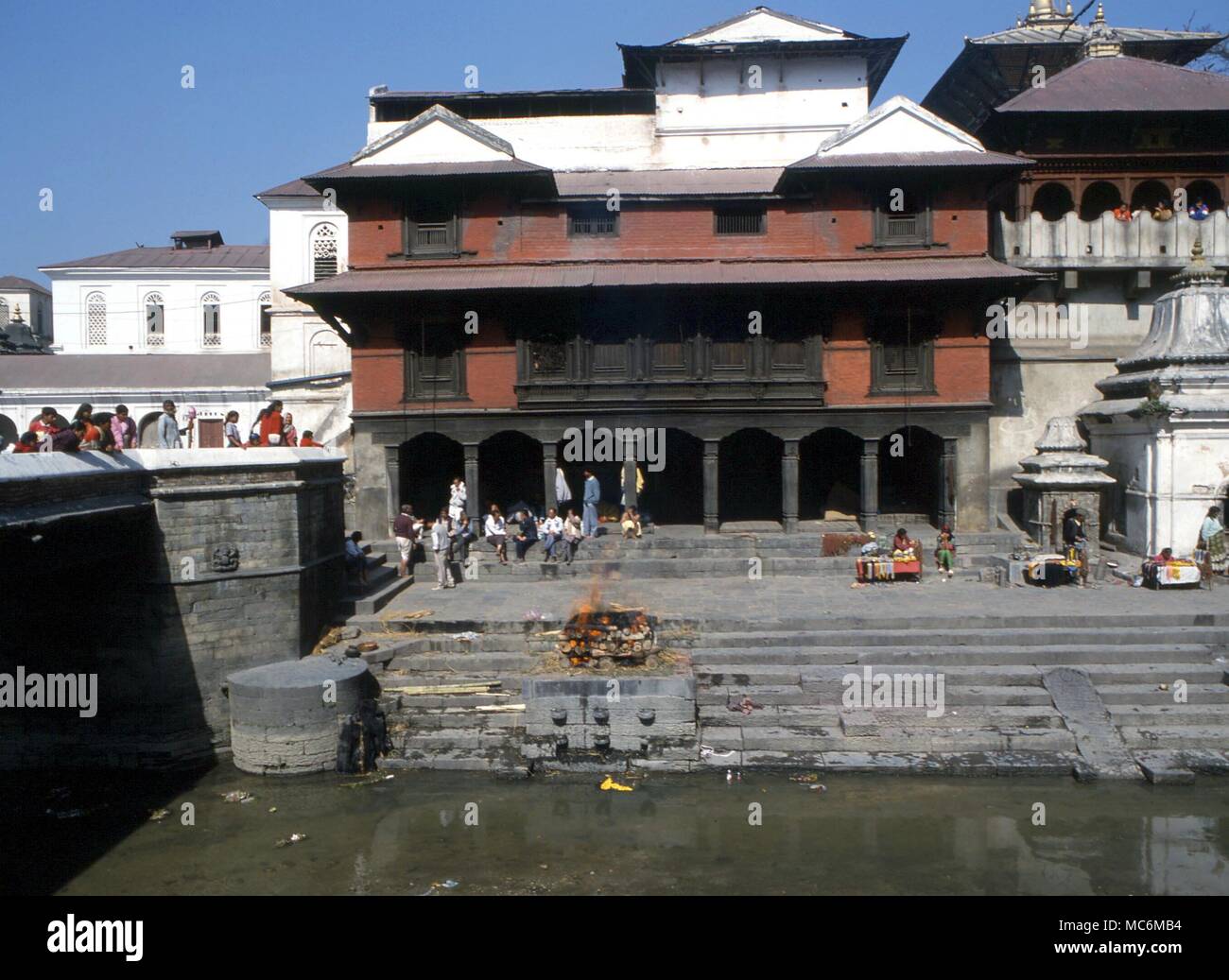 - Décès crémation hindou de l'Inde à la crémation d'un corps mort par la rivière Bagmati (vallée de Katmandou). Le fils, après avoir marché autour du cadavre trois fois, attendent le bûcher Banque D'Images