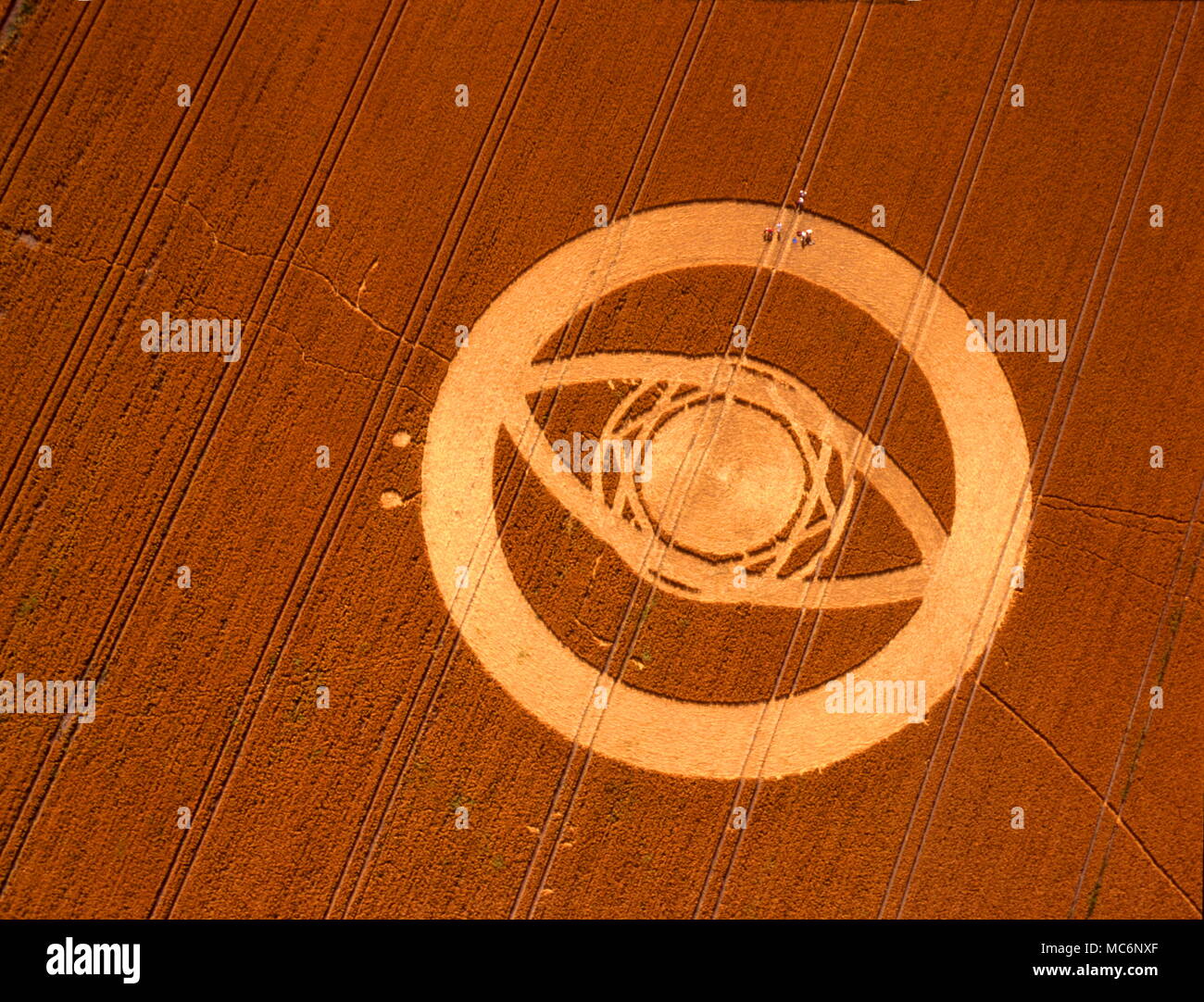 Cercle de maïs sous la forme d'un œil géant, encerclé par bande circulaire blanc. Photographié ci-dessous à partir d'hélicoptères de Huish Ridge, au nord-ouest de Pewsey, août 1994. Remarque la présence de personnes dans le cercle. Banque D'Images