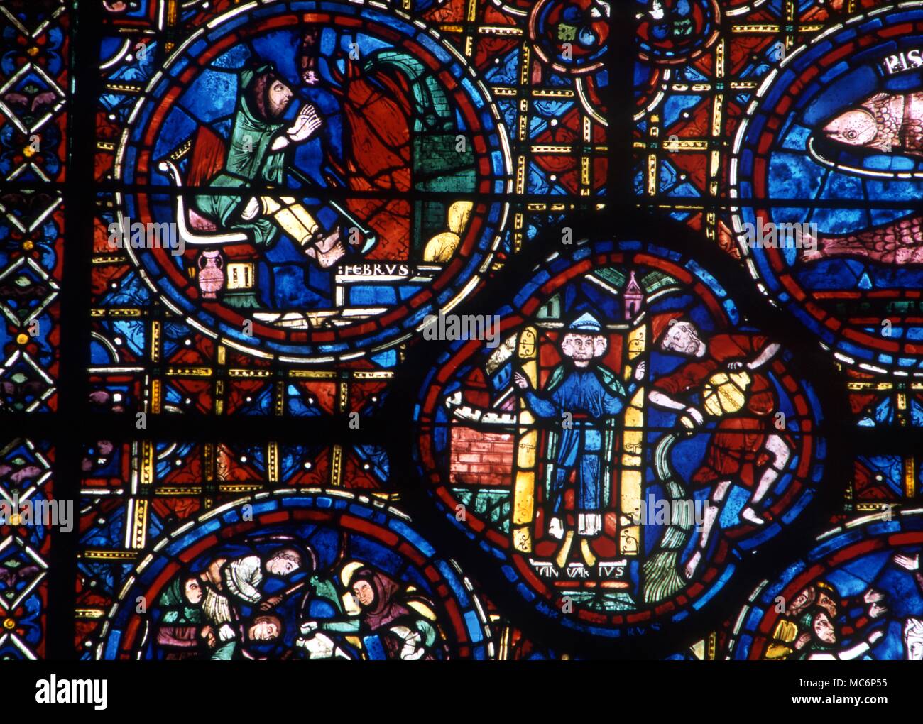 Cocardes dans vitrail montrant l'image pour février, de se réchauffer devant un feu. Ci-dessous est un quadrilobe du mois de janvier. Douzième siècle, Cathédrale de Chartres. 2004 Charles Walker / Banque D'Images