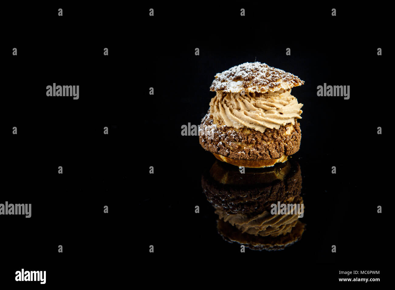 Français savoureux dessert profiterole avec la crème caramel servi sur fond miroir noir avec reflet Banque D'Images