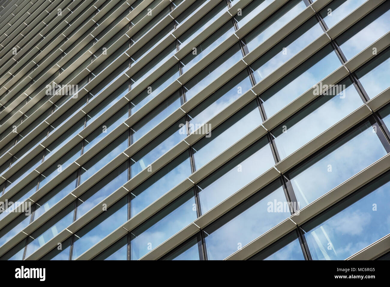 Les nuages reflètent dans immeuble de bureaux modernes de Windows Banque D'Images