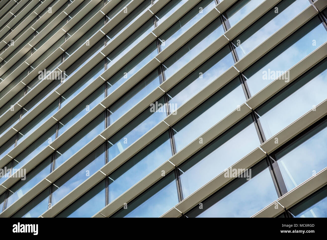 Les nuages reflètent dans immeuble de bureaux modernes de Windows Banque D'Images