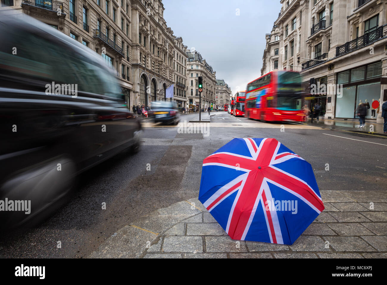 Londres, Angleterre - parapluie britannique occupé à Regent Street avec rouge emblématique des autobus à deux étages et les taxis noirs en mouvement Banque D'Images