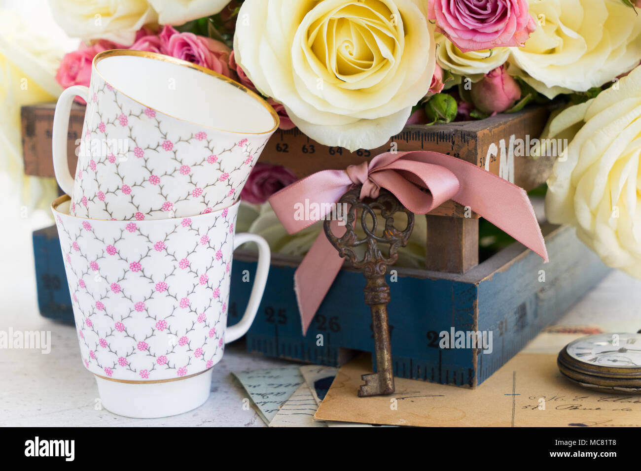 Rosiers rose et blanc avec deux tasses de café et un key Banque D'Images