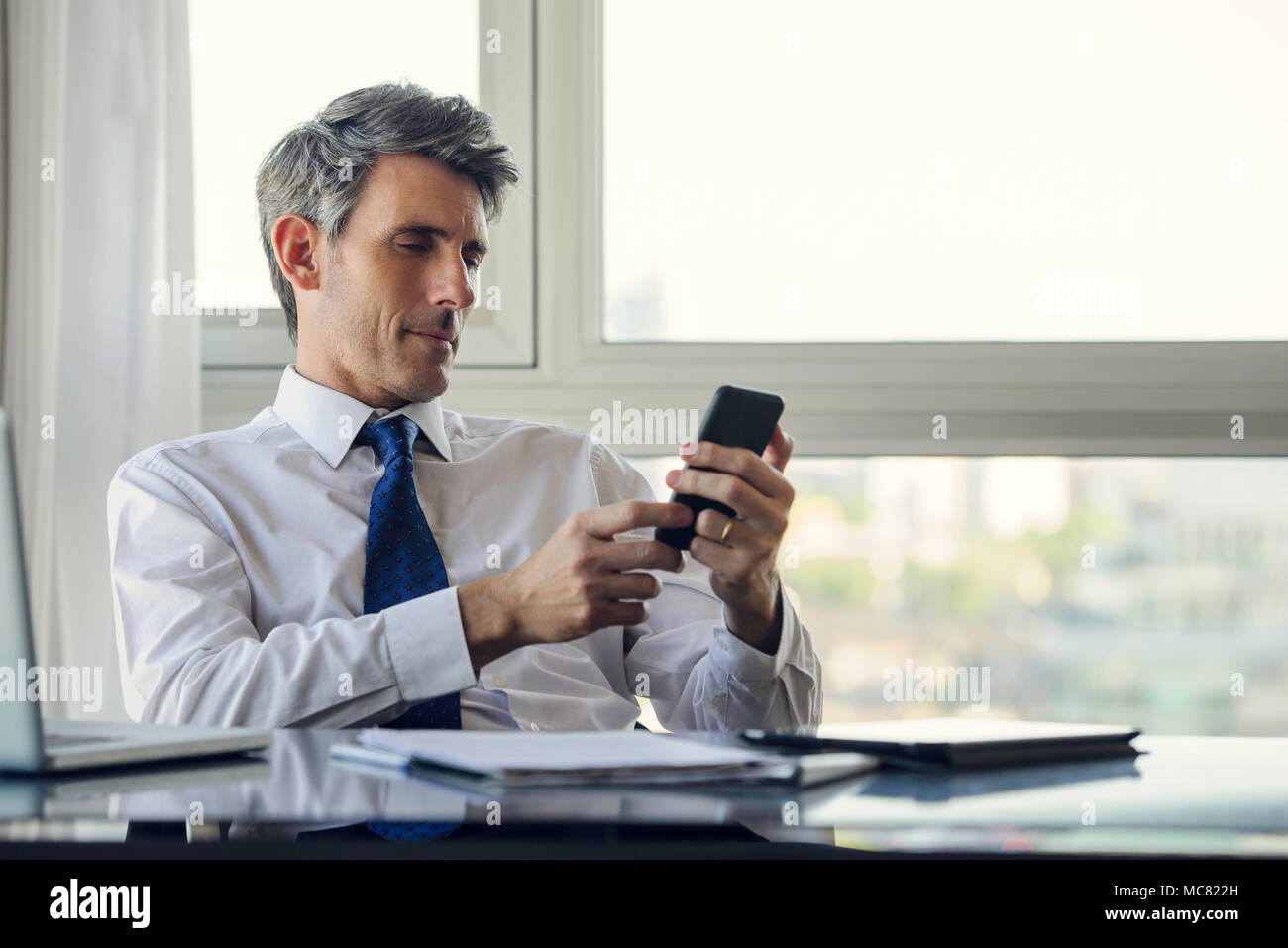 L'homme à l'aide de smart phone in office Banque D'Images