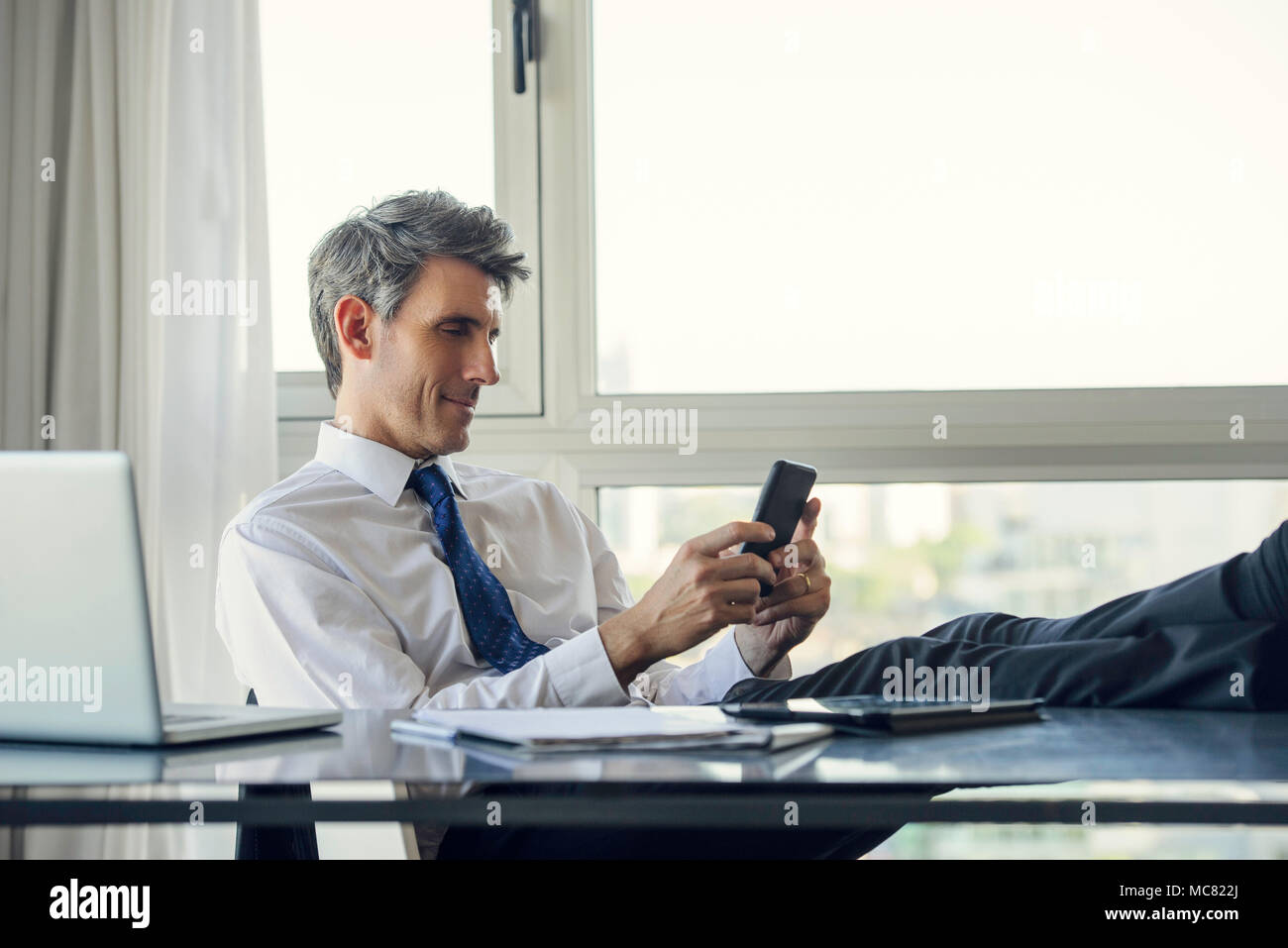 L'homme à l'aide de smart phone in office Banque D'Images