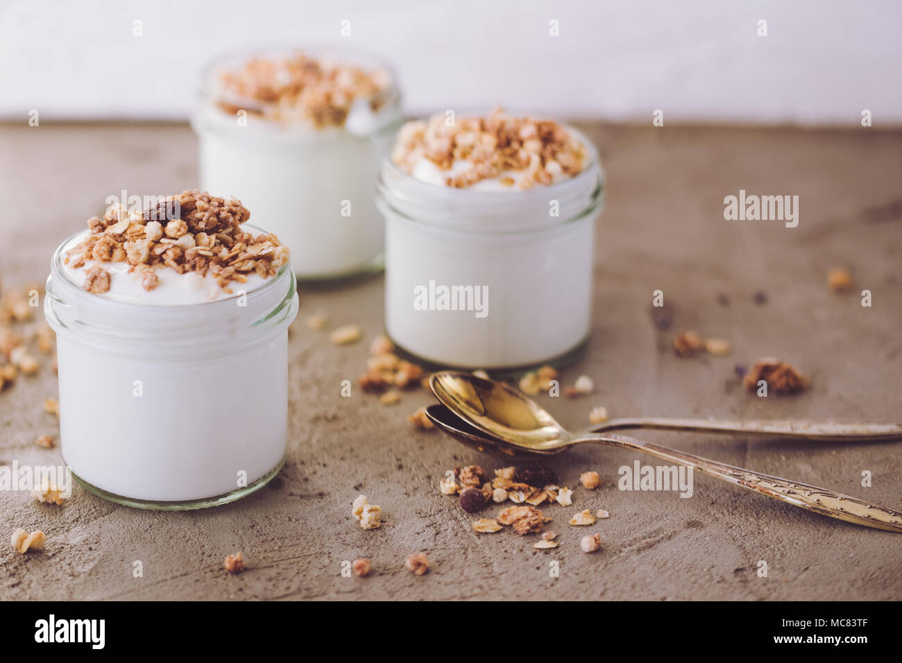 Yaourt au muesli fait d'avoine, raisins secs, riz soufflé, de chocolat et de bananes séchées. Petit-déjeuner sain pour la famille. Alimentaire sain. Banque D'Images