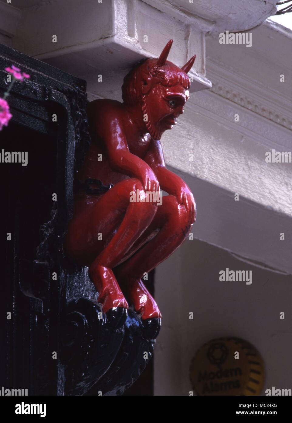 "Démoniaque" à caryatide sur le côté d'une vitrine dans l'État de New York, Yorkshire. Ce diable rouge est presque certainement un vestige de l'époque quand la boutique a été utilisé par une imprimante, et l'image était un signe de "l'apprenti imprimeur'. Banque D'Images