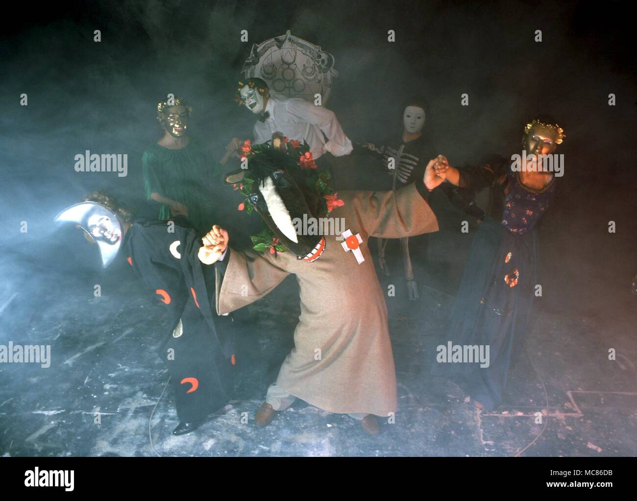 La sorcellerie groupe de personnes dans une sorcellerie burlesque, vêtus de costumes bizarres et des masques, la danse à l'intérieur d'un cercle magique Banque D'Images