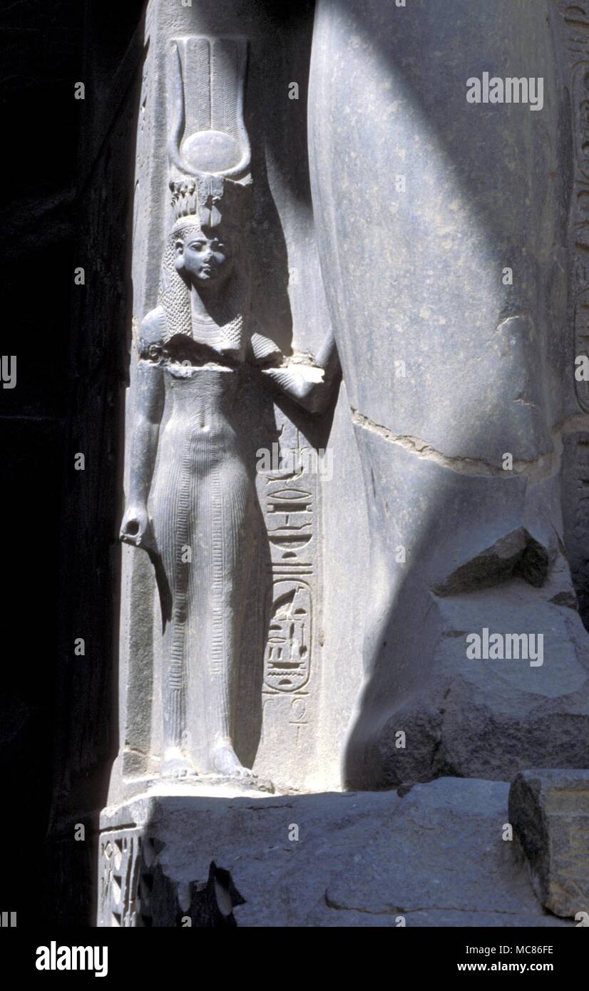 La déesse Isis sous les jambes de géant de Ramsès II, dans le temple de Louxor, Egypte mythologie égyptienne, la déesse Hathor, avec le solaire-lunaire : Harnais de secours de granit dans le cadre de la gigantesque statue de Ramsès II. Dans la salle hypostyle du temple de Louxor Banque D'Images