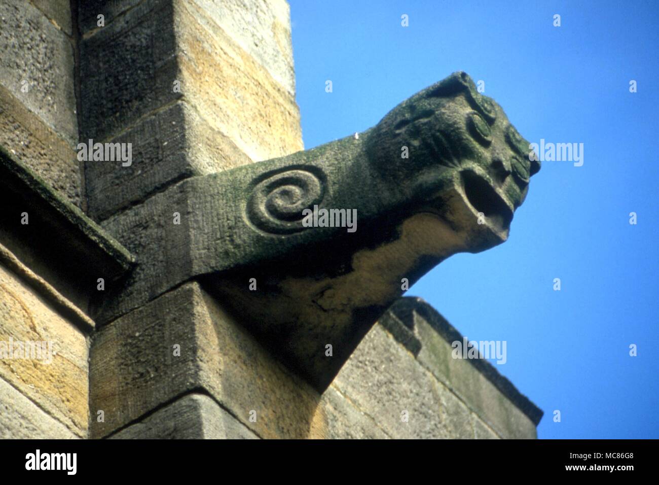 Gargouille gargouille sculptée en spirale avec de chaque côté comme symbole occulte. Sur le mur sud de l'église paroissiale, Littleborough Banque D'Images