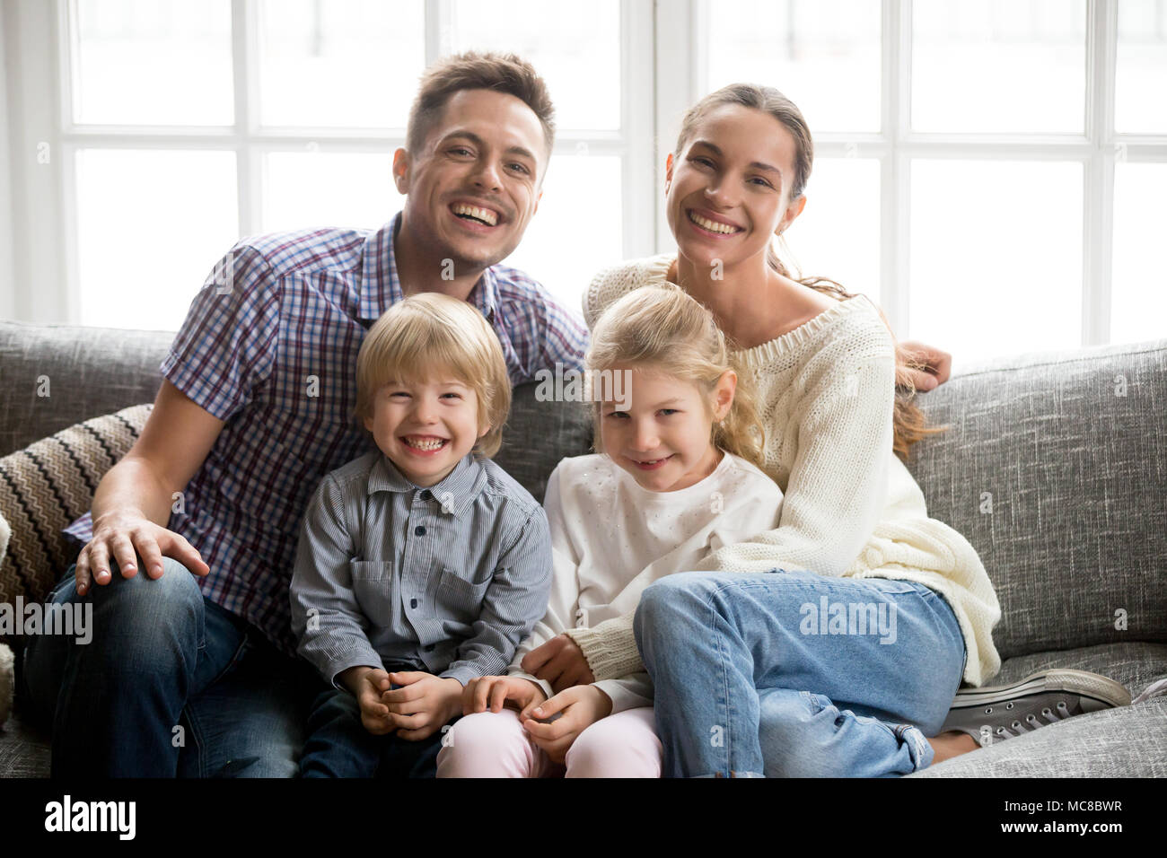 Portrait de famille multinationale heureux avec les enfants adoptés de rire ensemble, de collage smiling young couple embracing boy fils et fille fille assise o Banque D'Images