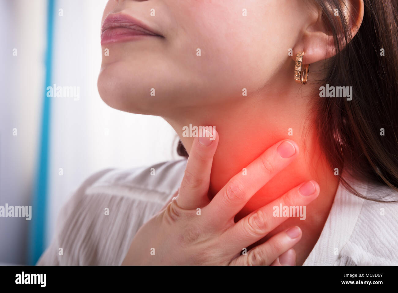 Close-up of a Woman's Hand Touching son mal de gorge Banque D'Images