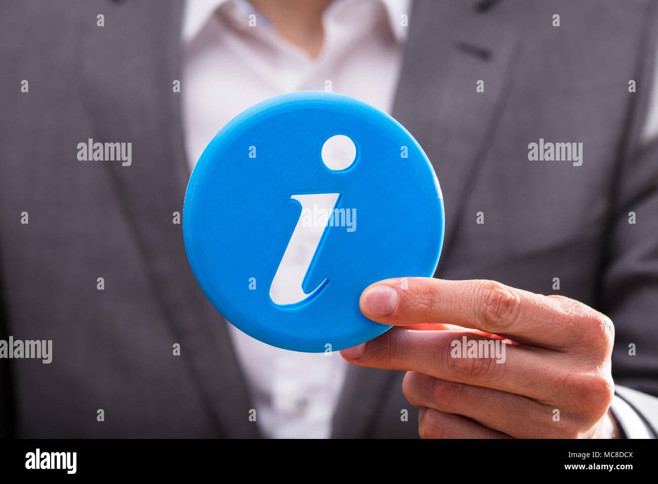 Close-up de l'homme d'affaires's Hand Holding Blue Icône Information Banque D'Images