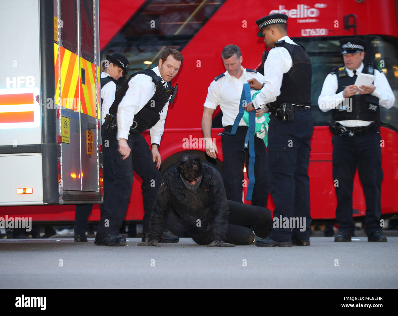 Les agents de police déposer un manifestant qui s'est coincé sous un fourgon de police, au cours d'une manifestation contre une intervention militaire en Syrie, dans la région de Whitehall, Londres. Banque D'Images