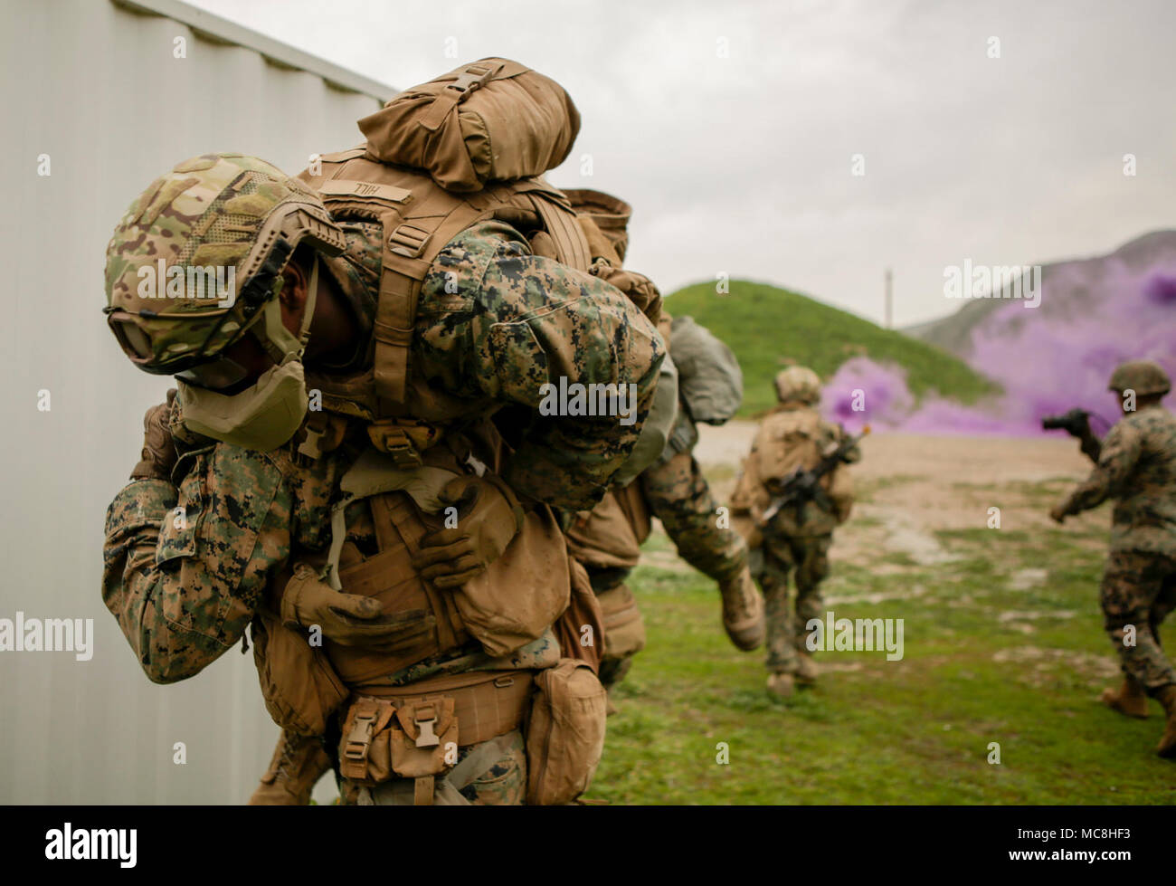 Les Marines américains avec 3e Bataillon, 4e Marines, la Compagnie Kilo courir vers leur prochain objectif à travers la fumée tout en transportant un pompier en stimulée scénario réaliste au cours de l'exercice de la technologie navale avancée urbaine 2018 (ANTX18) à Camp Pendleton, Californie, le 22 mars 2018. Les marines sont en train de tester les technologies de nouvelle génération pour fournir l'occasion d'évaluer l'utilité opérationnelle des technologies émergentes et des innovations qui améliorent la survie du marin, la létalité et la connectivité dans des environnements urbains complexes. Banque D'Images