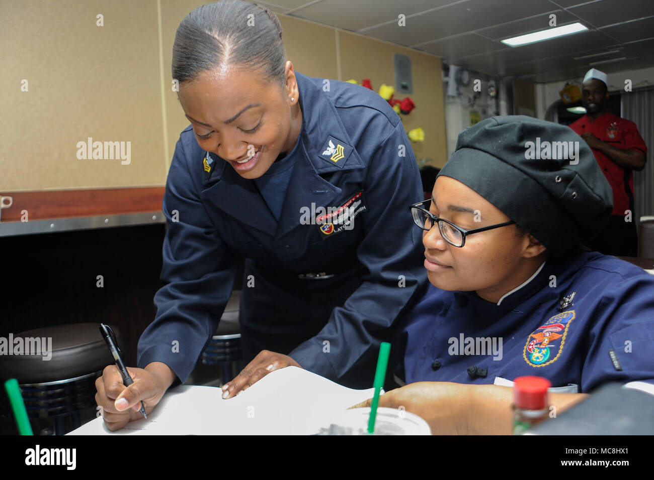 Océan (29 mars 2018) 1ère classe spécialiste culinaire LaToya Farrish, originaire de Caswell Comté, N.C. et la Flotte du Pacifique 2018 marin de l'année, signe un enrôle Surface Warfare personnel spécialisé Norme de qualification spécialiste culinaire Crystal 3e classe Wilkins, originaire de Jackson, au Mississippi, sur le gâchis pont du Wasp-classe d'assaut amphibie USS Essex (DG 2) lors d'un escadron amphibie et Marine Expeditionary Unit (MEU) intégration (PMINT) de l'exercice. PMINT est une évolution de la formation entre l'Essex et le 13e Groupe amphibie MEU, qui permet aux marins et Marines de trai Banque D'Images