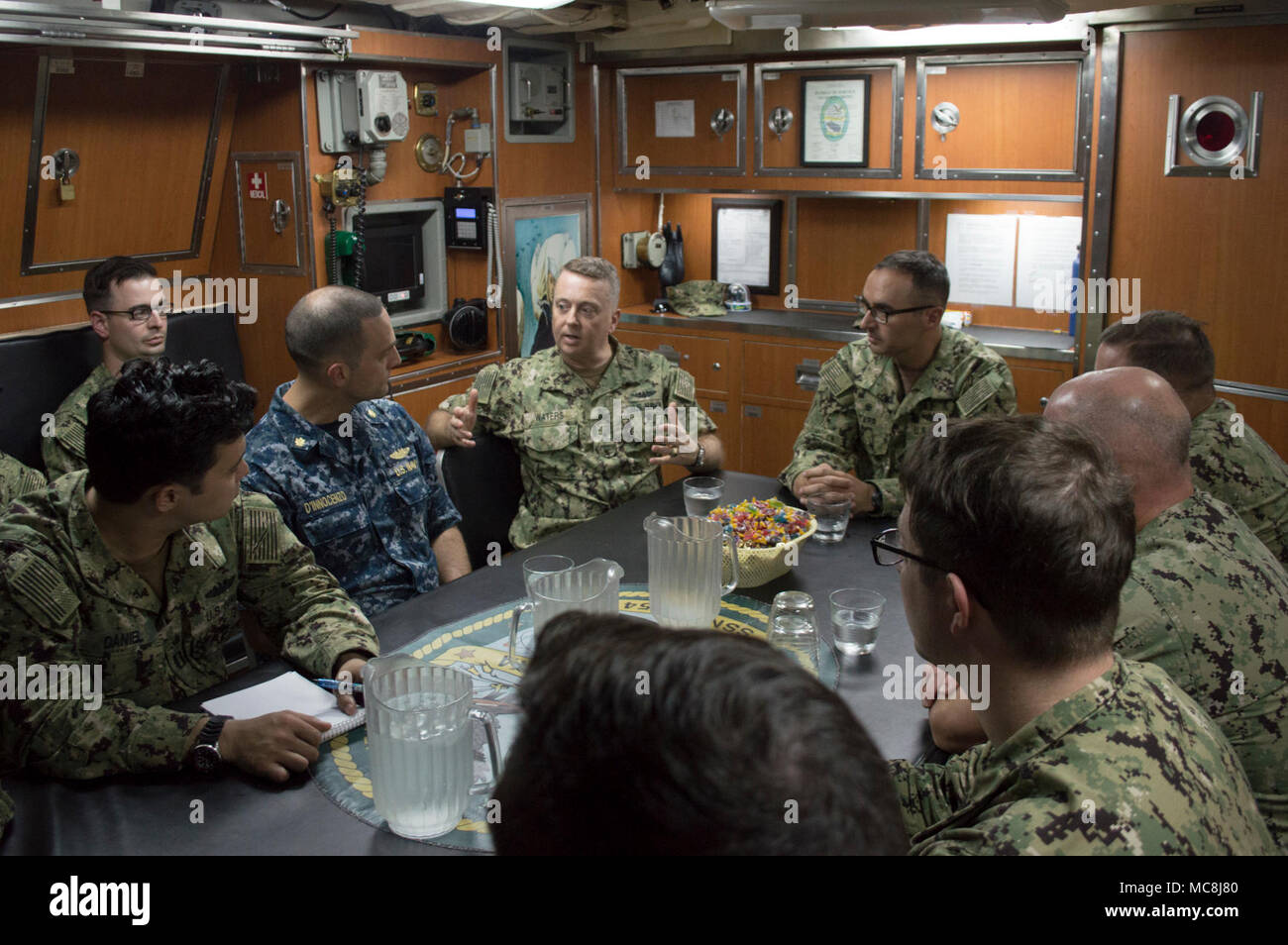 APRA HARBOUR, Guam (2 avril 2018) Arrière Adm. Eaux James III, directeur, Maritime, siège de la flotte américaine du Pacifique, centre gauche, traite de l'appui de sous-marins et insuffisances des succès avec les marins affectés à Los Angeles-classe d'attaque USS Topeka (SSN 754) lors d'une visite à bord, le 2 avril. Waters s'est entretenu avec les commandes de la marine à Guam pour discuter d'entretien du navire et les capacités logistiques et de leurs préoccupations. Banque D'Images