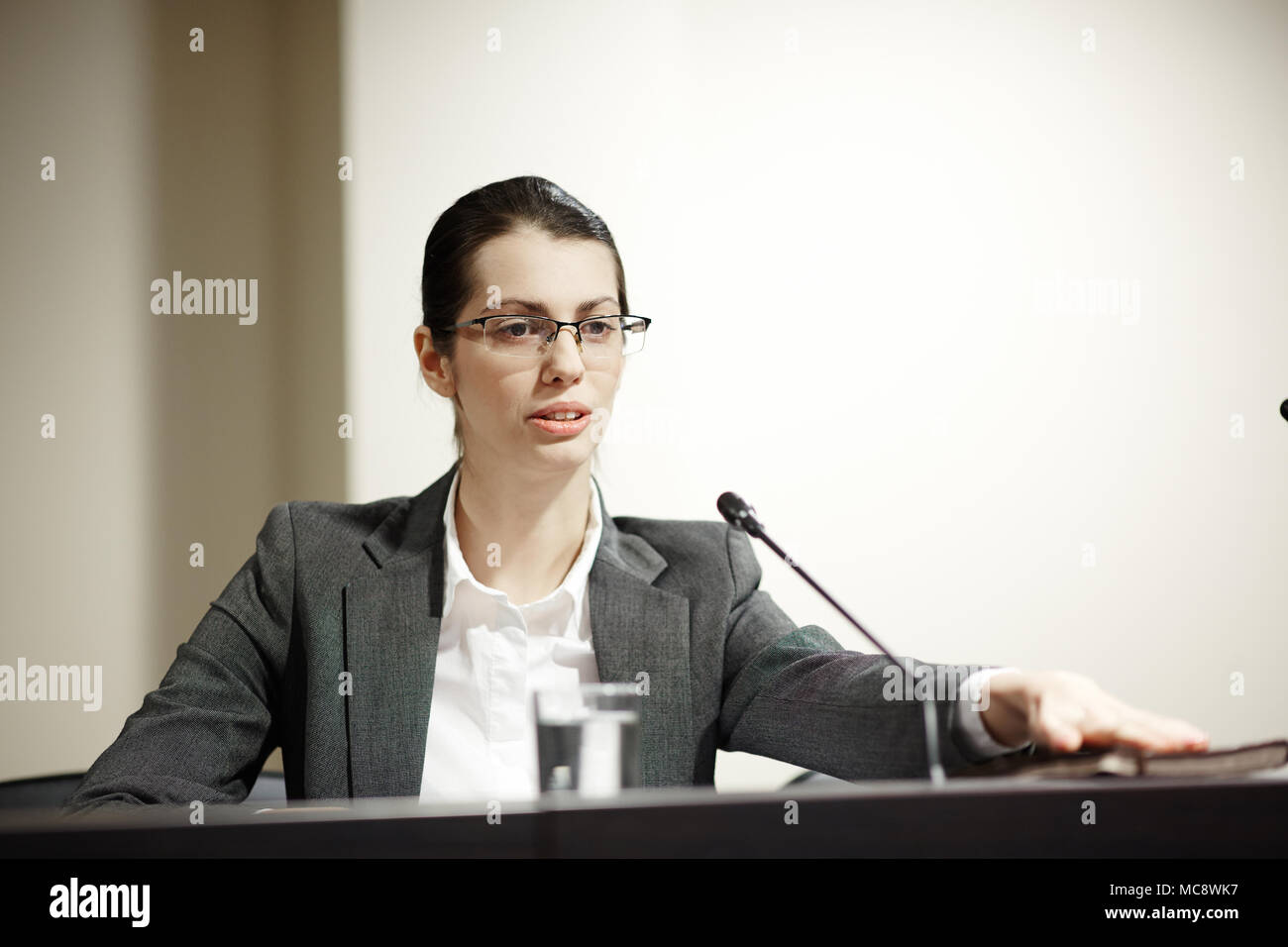 Jeune femme délégué en tribune discours faisant pour d'autres participants du sommet politique Banque D'Images