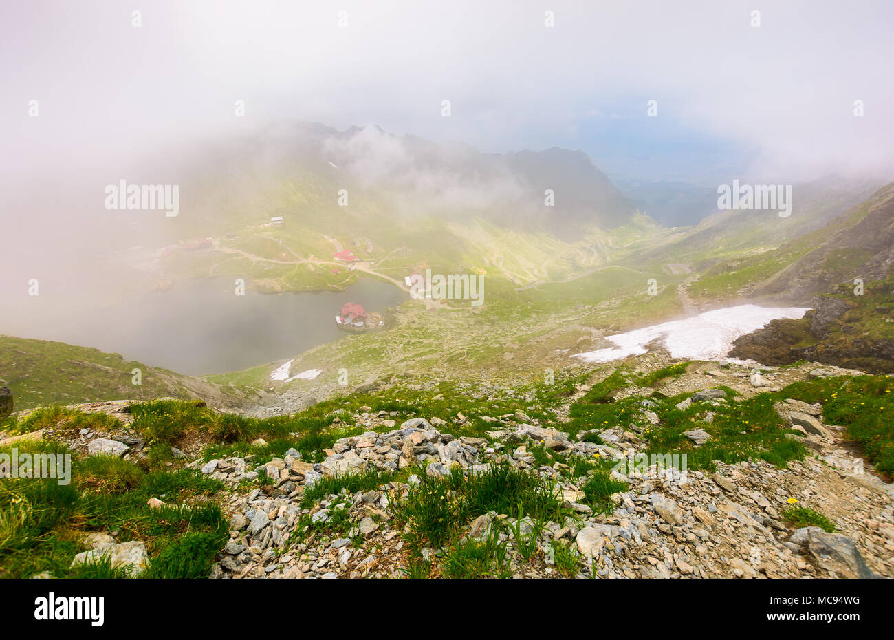 Balea lac dans le brouillard vue depuis le haut. joli paysage d'été avec les nuages bas autour de Banque D'Images