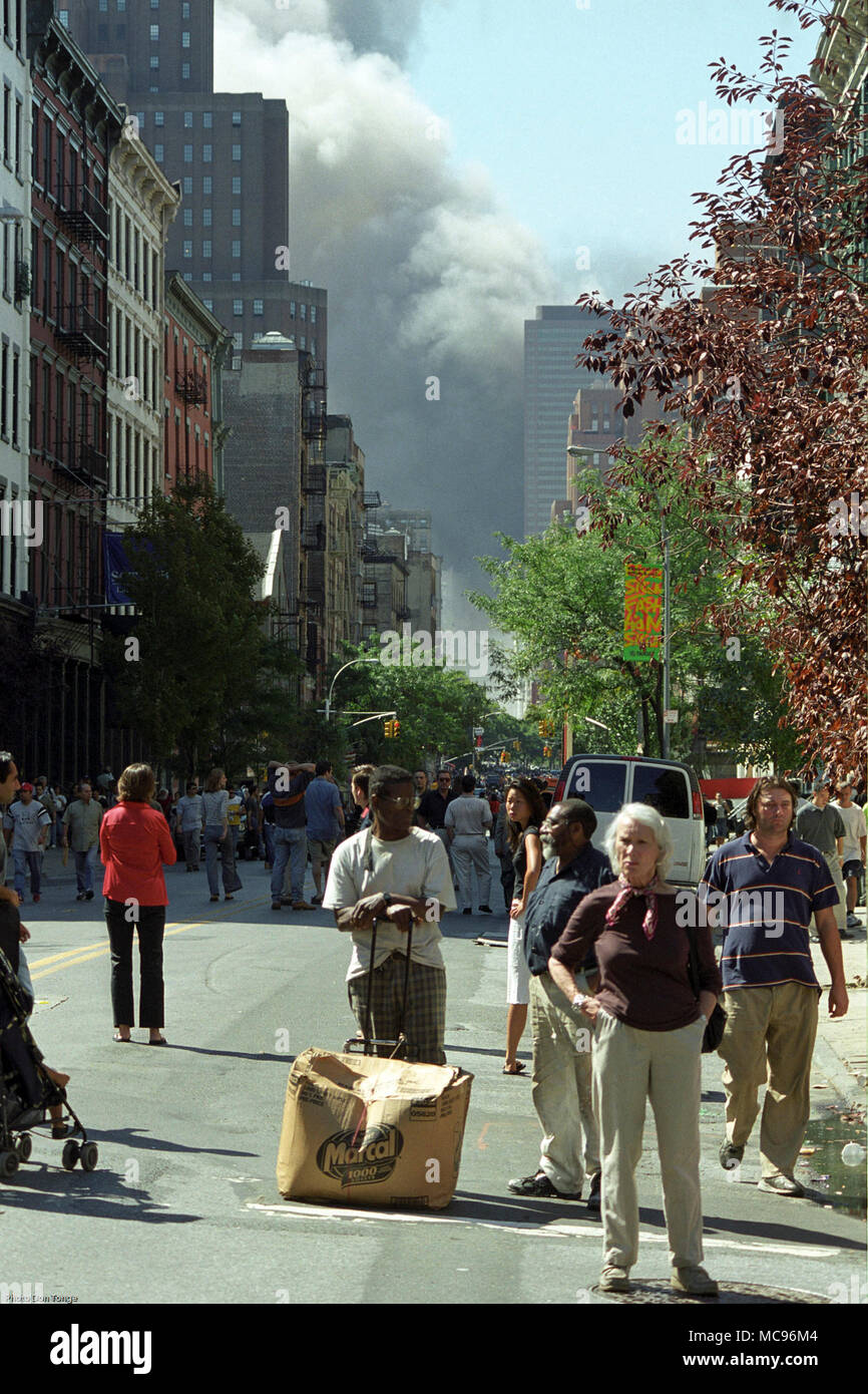 Les New-yorkais se tenir en état de choc et d'incrédulité que la fumée s'élève dans le ciel après l'attaque terroriste sur le World Trade Center de New York le 11 septembre 2001 DON photo photographe TONGE Banque D'Images