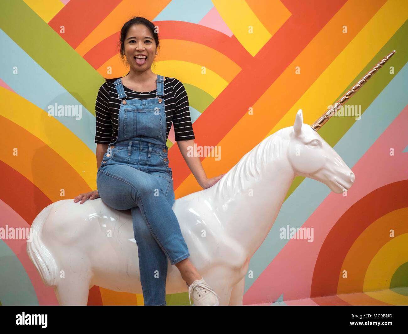 Jeune femme assise sur une licorne au Musée de glace à San Francisco, CA Banque D'Images