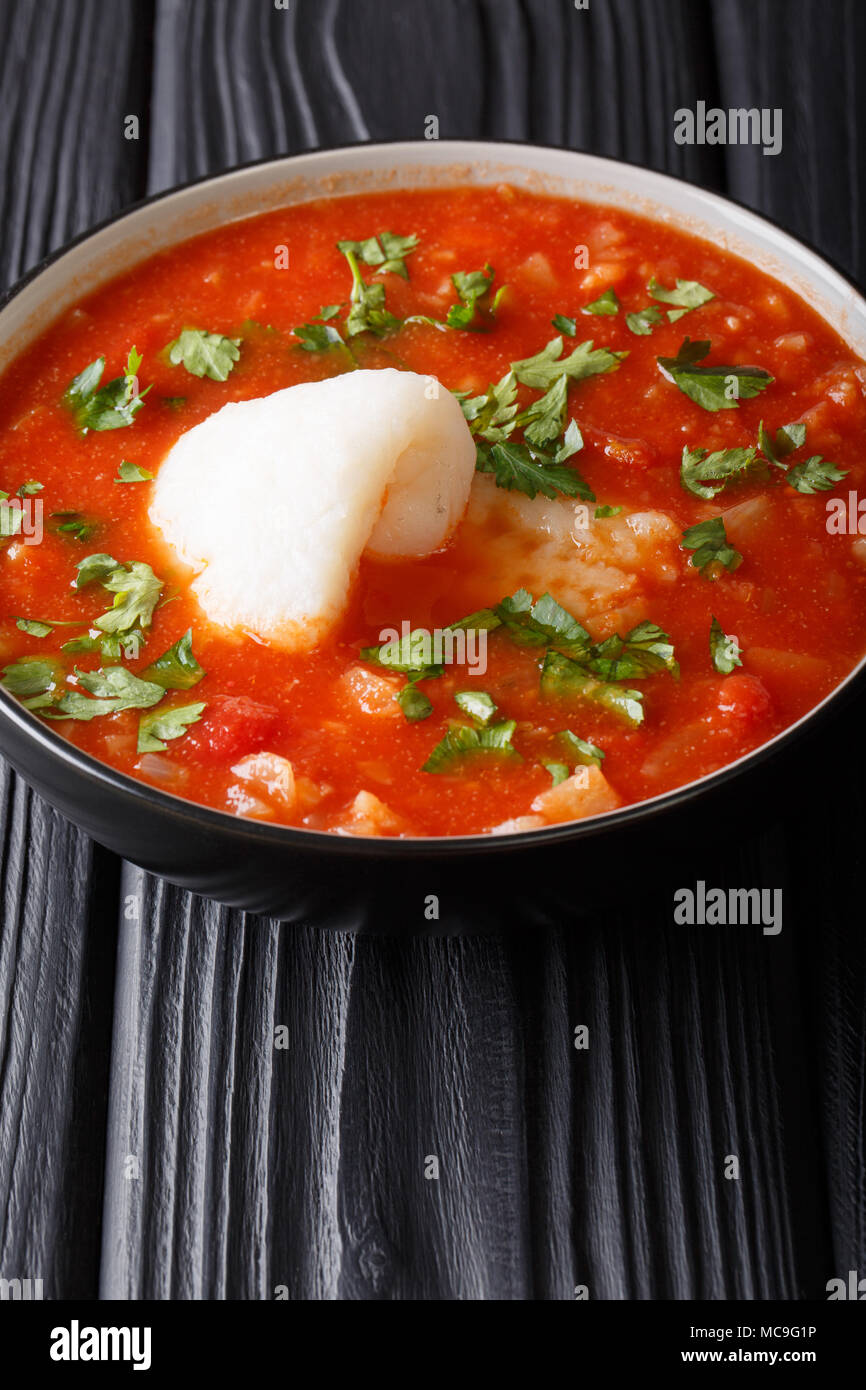 Poisson sicilien soupe de tomate avec des légumes close-up dans un bol sur la table verticale. Banque D'Images
