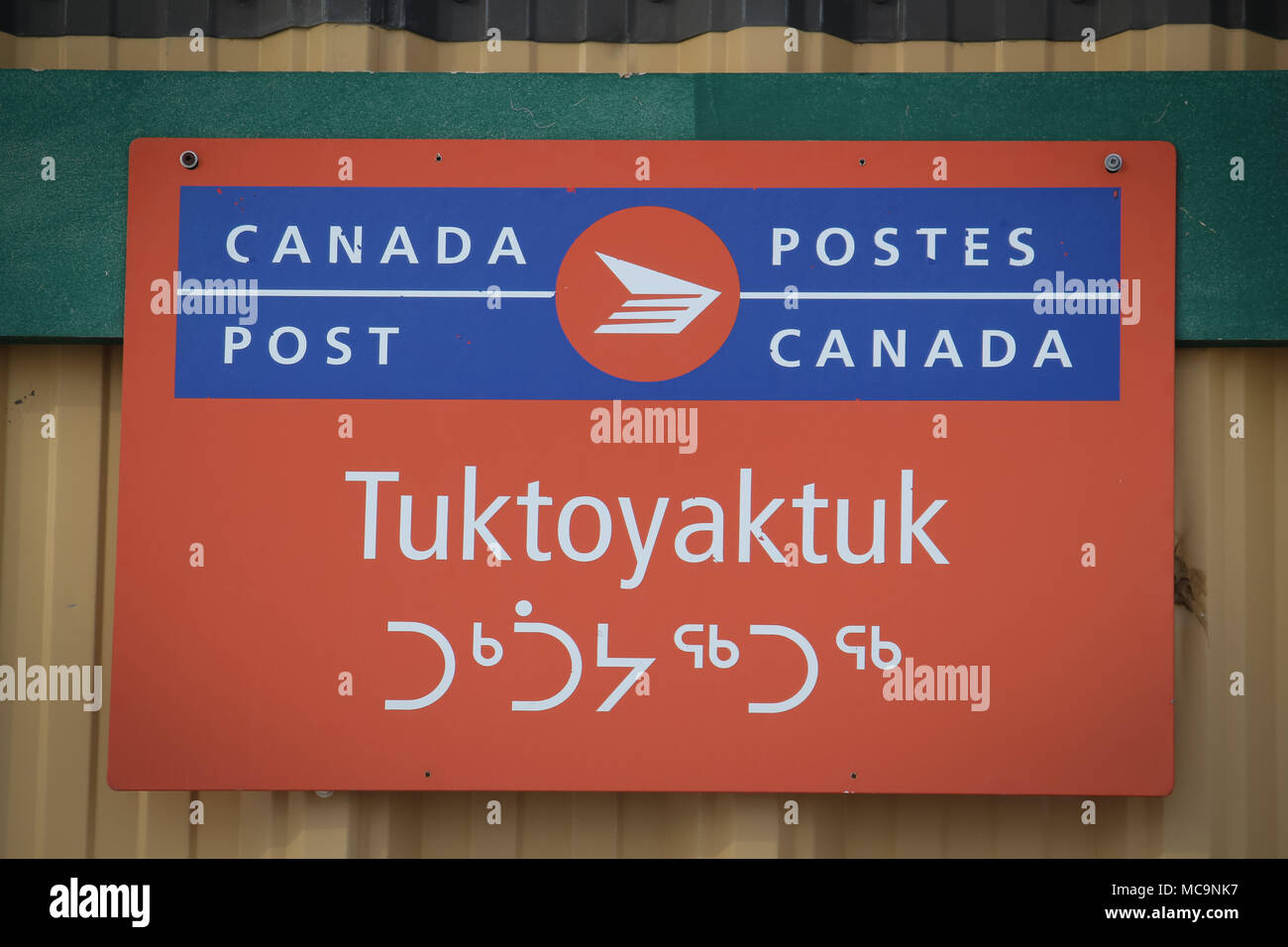 Le bureau de postes Canada signe le hameau inuvialuit de Tuktoyaktuk dans l'arctique, avec l'orthographe inuvialuktun de la communauté, Territoires du Nord-Ouest, Canada. Banque D'Images