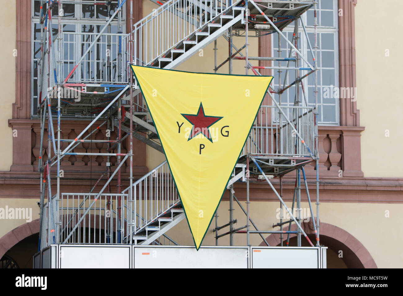 Mannheim, Allemagne. 14 avr, 2018. Un grand drapeau de la GPJ (unités de protection du peuple) se bloque sur le côté de la Mannheim Palace. Peuple kurde et partisans allemands ont défilé à Mannheim pour protester contre la poursuite de l'occupation de la ville syrienne d'Afrin, qui a été contrôlée par le populaire kurde des unités de protection (GPJ) avant qu'elle ne soit conquise par l'armée turque. Ils ont également protesté contre la participation allemande à l'exportation d'armes à la Turquie. Crédit : Michael Debets/Pacific Press/Alamy Live News Banque D'Images