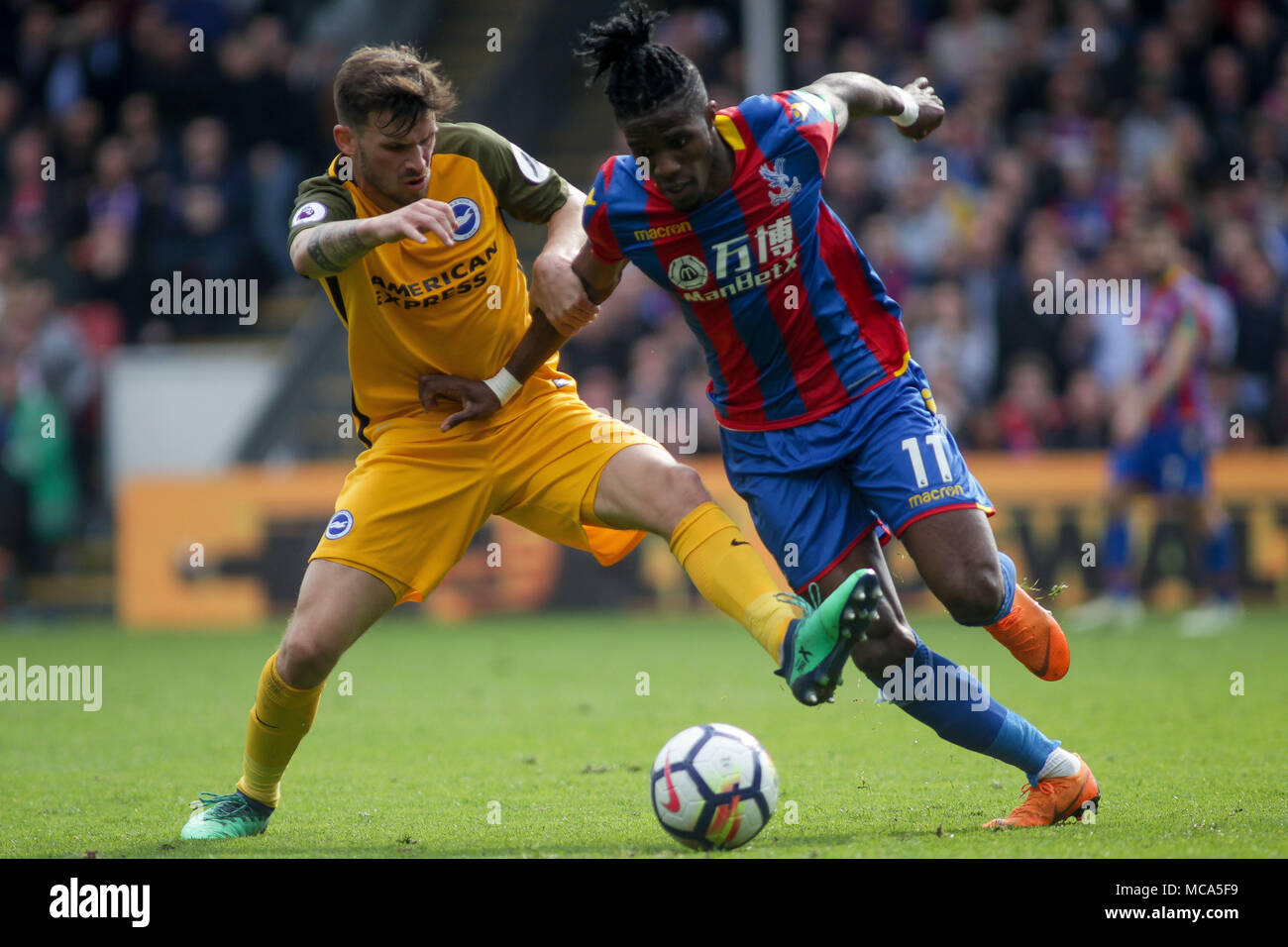 Londres, Royaume-Uni, 14 avril 2018. Wilfried Zaha de Crystal Palace et Pascal Gross, de Brighton, bataille pour la balle . Premier match de championnat, Crystal Palace v Brighton & Hove Albion à Selhurst Park à Londres le samedi 14 avril 2018. Photos par Kieran Clarke/Andrew Orchard la photographie de sport/Alamy Vivre newsEditorial uniquement, licence requise pour un usage commercial. Aucune utilisation de pari, de jeux ou d'un seul club/ligue/player Editorial uniquement, licence requise pour un usage commercial. Aucune utilisation de pari, de jeux ou d'un seul club/ligue/player Crédit : publications Andrew Orchard la photographie de sport/Alamy Banque D'Images