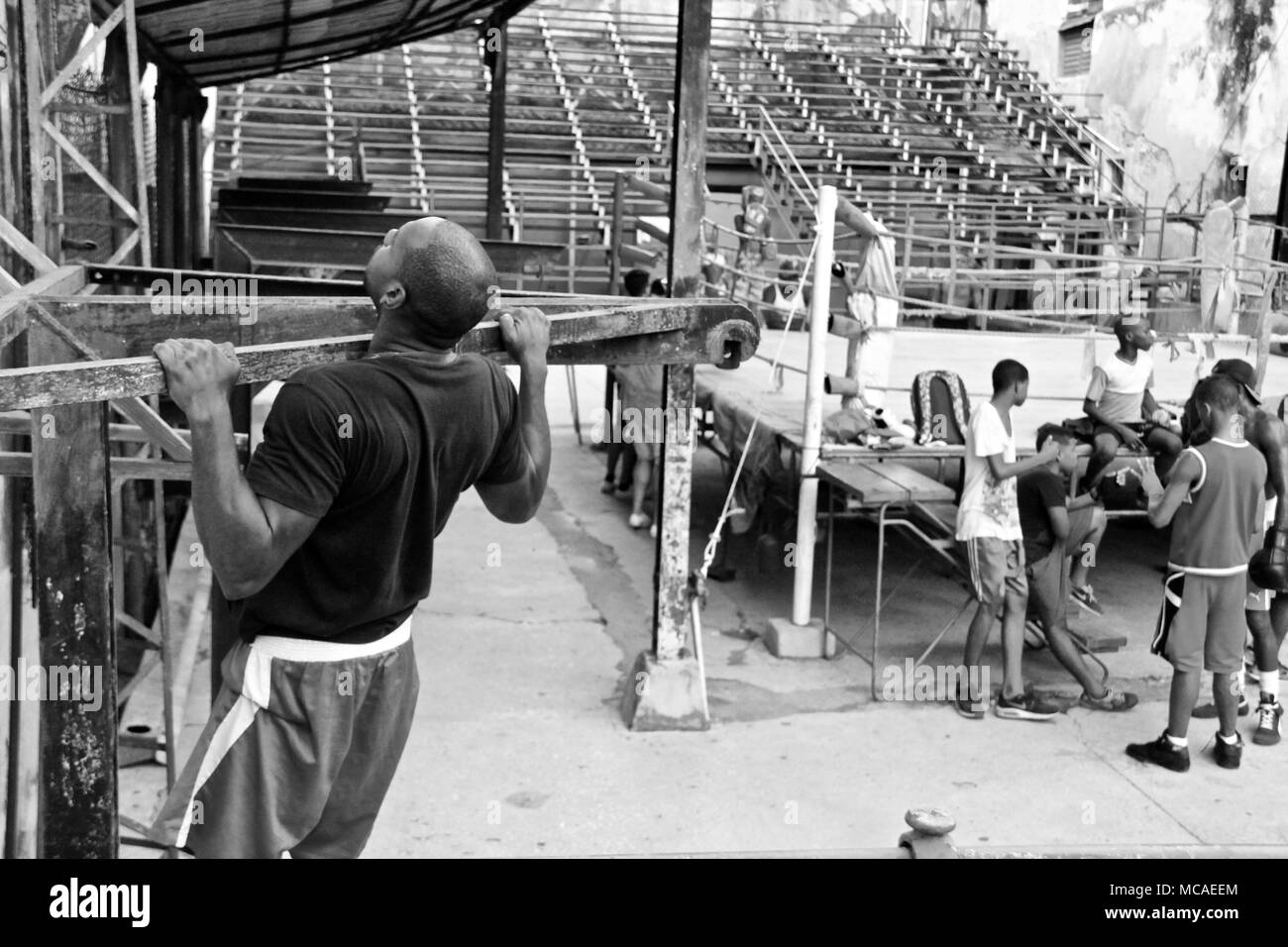 Une photo en noir et blanc d'un homme avec un t-shirt noir faisant un tirer vers le haut dans le ring à La Havane, Juillet 2017 Banque D'Images