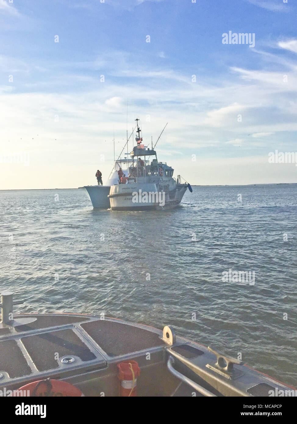 Un bateau de sauvetage à moteur de 47 pieds à partir de la gare d'équipage de l'Oregon, Caroline du Nord, contribue à assécher et gratuitement les 50 pieds, navire de pêche commerciale près de Big Kahuna Oregon Inlet 1 Février, 2018. Big Tahuna initialement perdue le pouvoir et a dérivé dans une aide à la navigation, ce qui entraînerait leur raccrocha et prendre l'eau. (U.S. Photo de la Garde côtière par Fireman Ryan Sexton/libérés) Banque D'Images