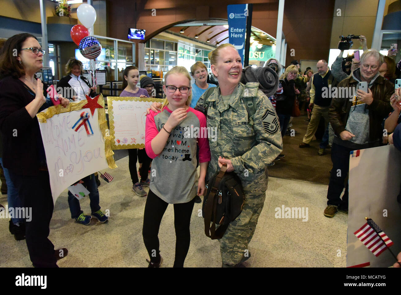 U.S. Air Force capitaine principal Sgt. Susan Schroeder, de la 119e vol de la communication, tient sa fille serré qu'elle est accueillie par la famille et les amis à son retour à l'accueil de l'Aéroport International Hector, Fargo, N.D., 6 février 2018. Bien qu'il existe presque toujours quelques membres de l'unité déployée à travers le monde à un moment donné, elle est le dernier membre de l'Heureux près de 150 hooligans qui déployés dans le cadre de l'unité de l'air du cycle de déploiement de la Force expéditionnaire du Canada en 2017. (U.S. Photo de la Garde nationale aérienne capitaine principal Sgt. David H. Lipp) Banque D'Images