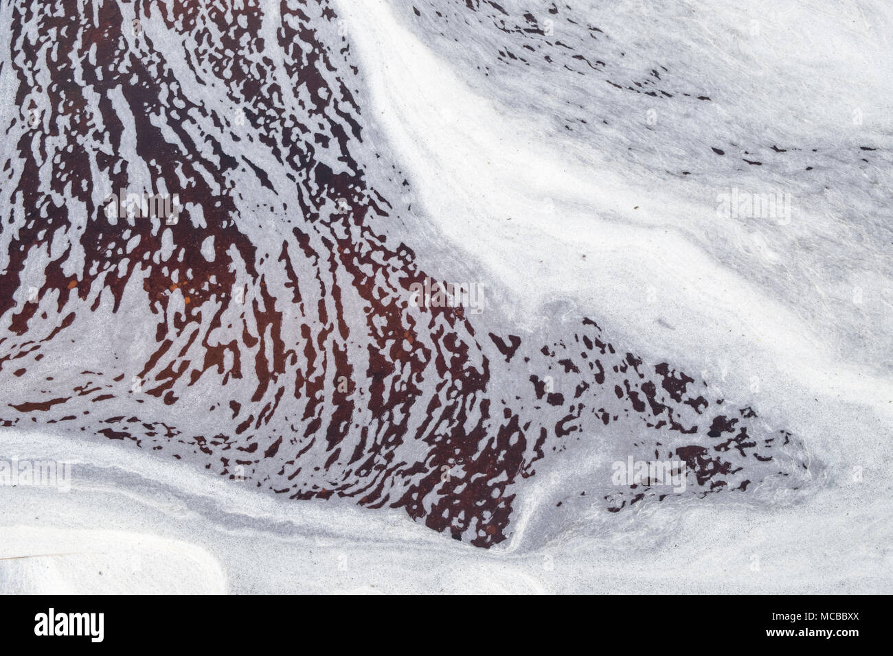 Abstraite de l'eau. Un flux avec de la mousse sur les Kinder Scout, Derbyshire Peak District, England, UK Banque D'Images