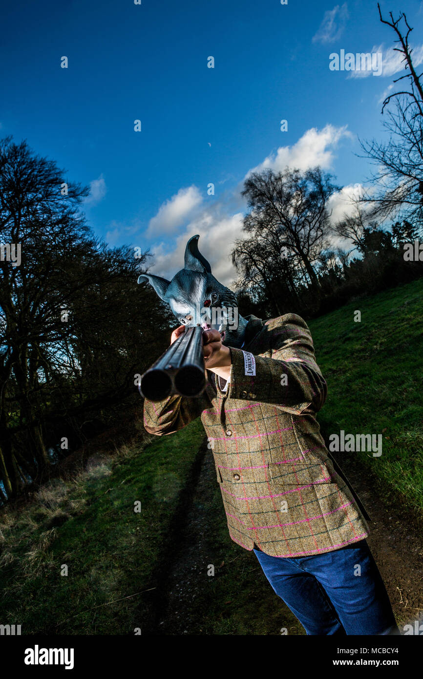 L'homme en costume et masque loup tient à huis clos de fusil Banque D'Images